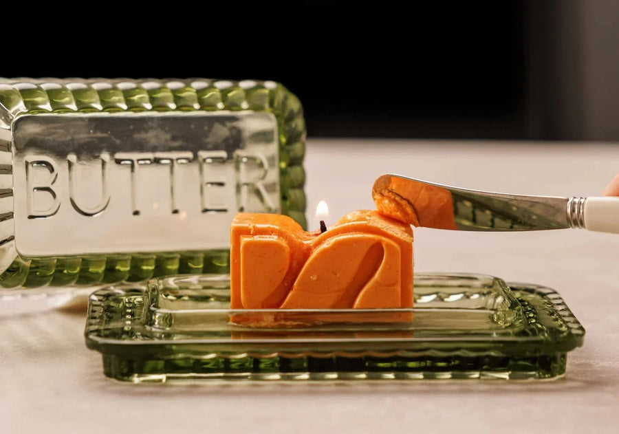 Elegante centro de mesa con velas encendidas, rodeado de detalles decorativos sutiles sobre una mesa de comedor sofisticada lista para una cena.